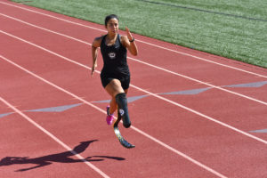 Ella Rodriguez running on the track for the high school adaptive sports program