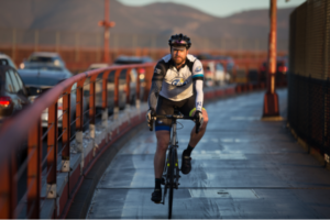 MDC participant biking over bridge