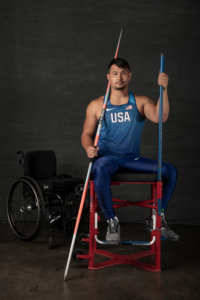 Justin Phongsavanh sitting on throwing chair with javelin in hand
