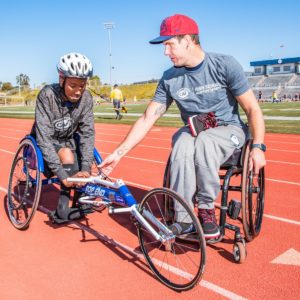 Erik Hightower mentoring high school student on racing chair