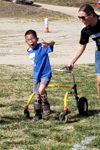 Daniel Lockwood walking with walker across grass