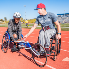 Erik Hightower mentoring high school student on racing chair