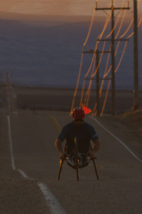 Josh Sweeney handcycling at sunset on open road
