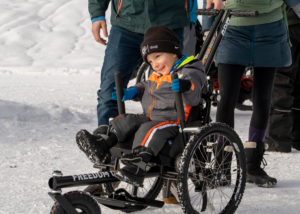 Teddy Wallace smiling in GRIT Freedom Chair Junior in snow