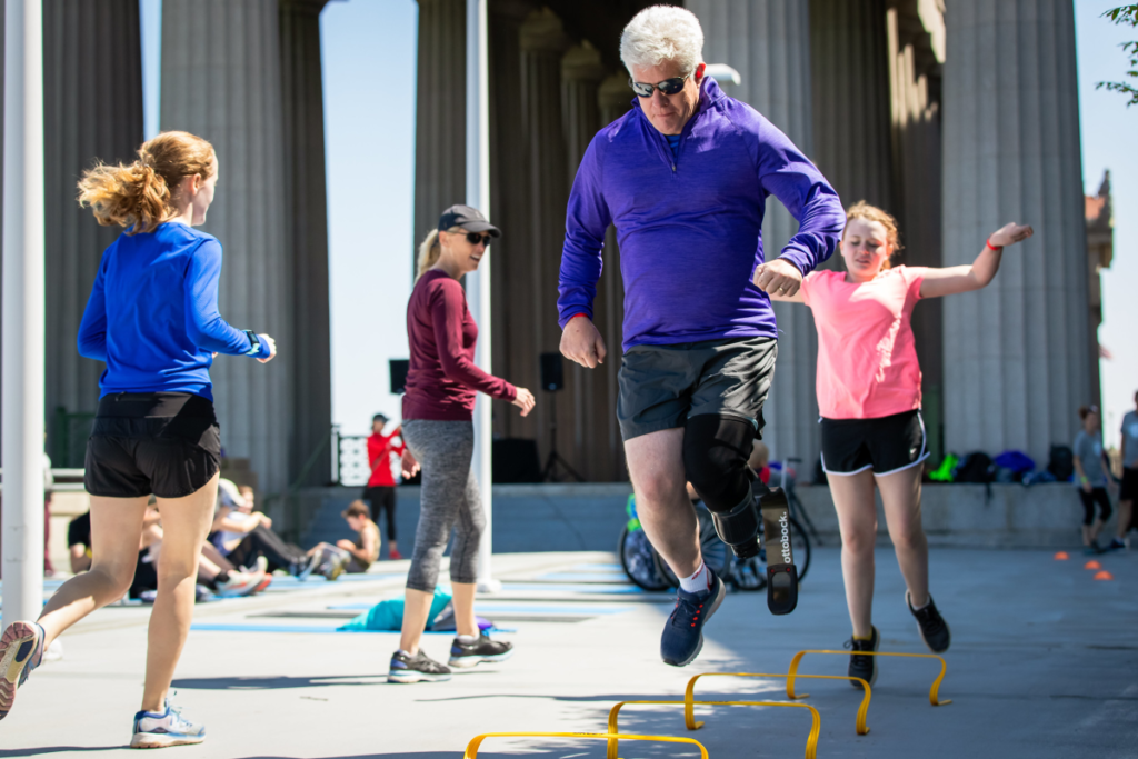 Chad Jerdee in prosthetic foot jumping over obstacles during workout