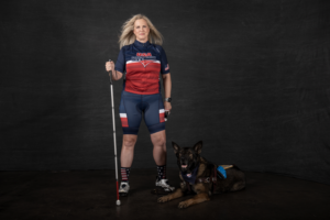 Amy Dixon with guide dog in USA Triathlon uniform