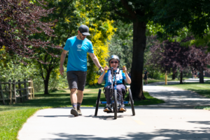 CAF athlete Esra on handcycle with volunteer Jason Daley