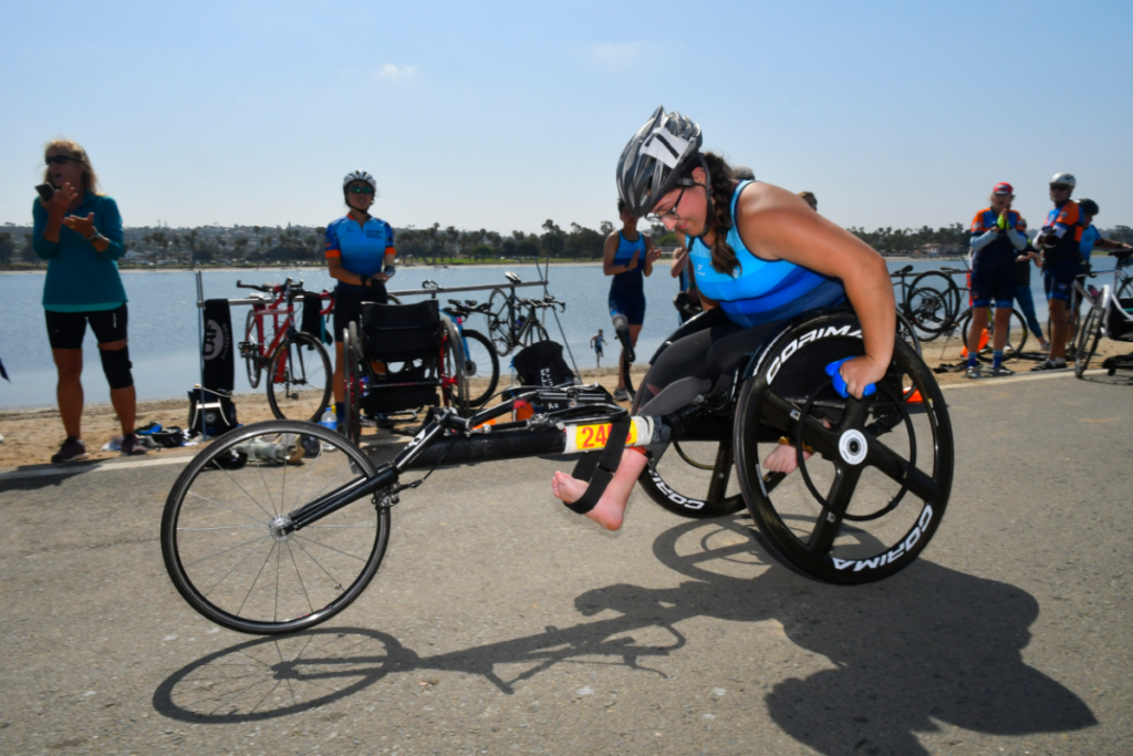 Sammy Rhodes in racing wheelchair on road next to San Diego Bay