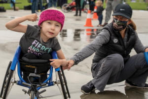 Clara Longoria at Wheelchair Racing Clinic in Idaho sitting in racing wheelchair. 1200X 800 PNG