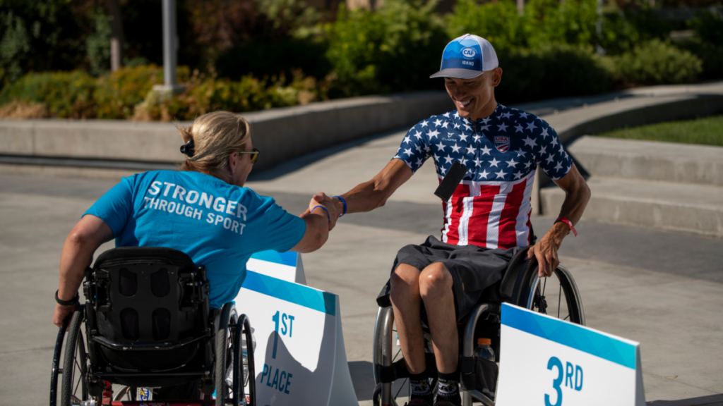 Will Groulx and Muffy Davis shake hands at podium