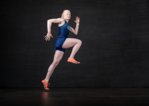 Kim Hightower in sprinter pose dressed in Team USA uniform against black backdrop