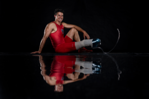 Trenten Merrill in red USA Track and Field uniform against black background