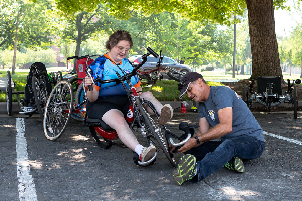 Mike Jennings assisting handcyclist with bike repair