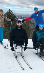 Josh Sweeney on sit ski in snow with other athletes