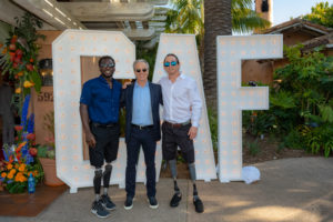 Roderick Sewell Scott Stackman and Rudy Tolson Garcia standing next to big CAF sign