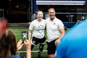Athlete with physical disability standing next to coach at a clinic