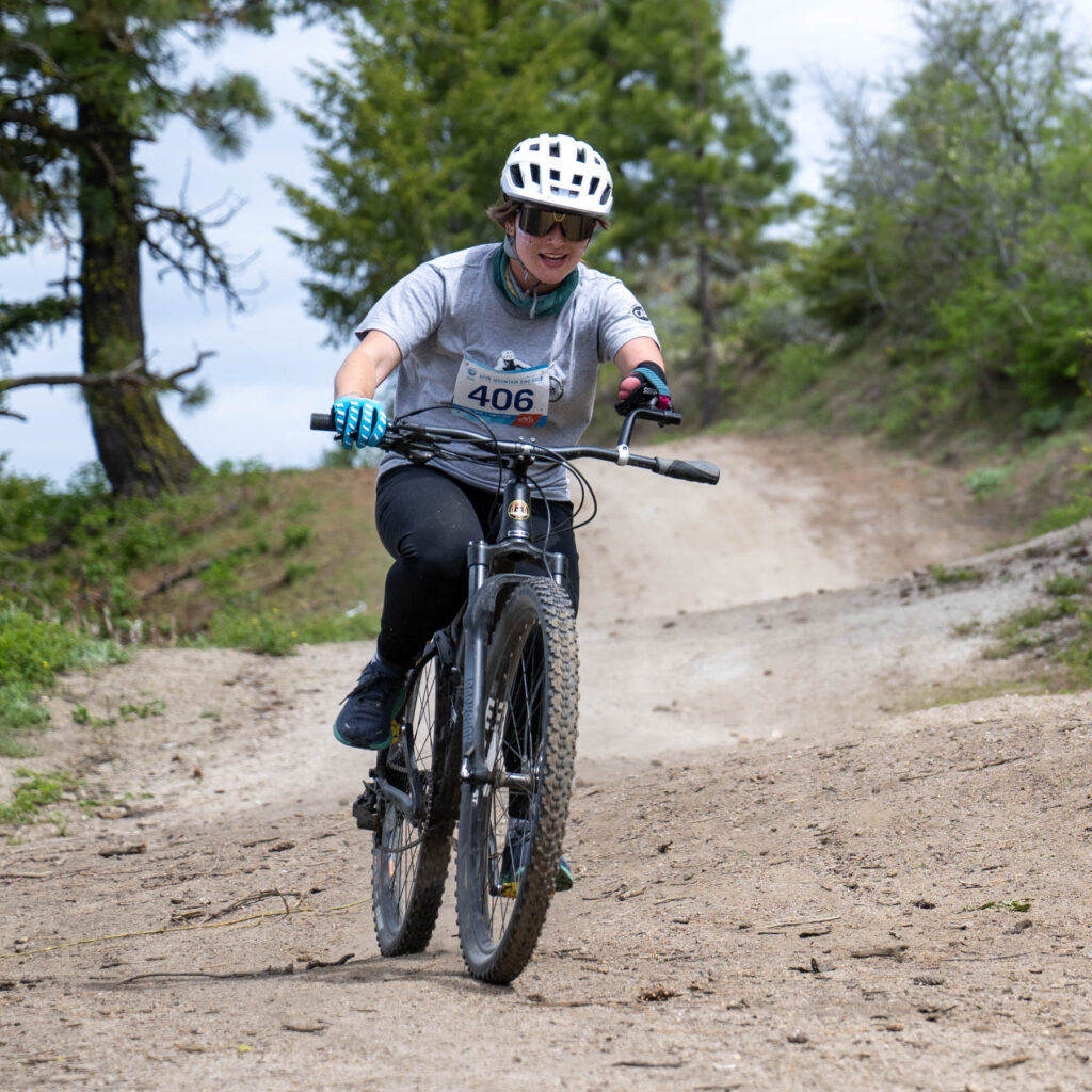 A person riding an upright cycle on a dirt trail.