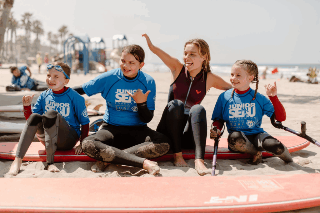 caf athlete liv stone at a surf clinic smiling surrounded by caf youth athletes