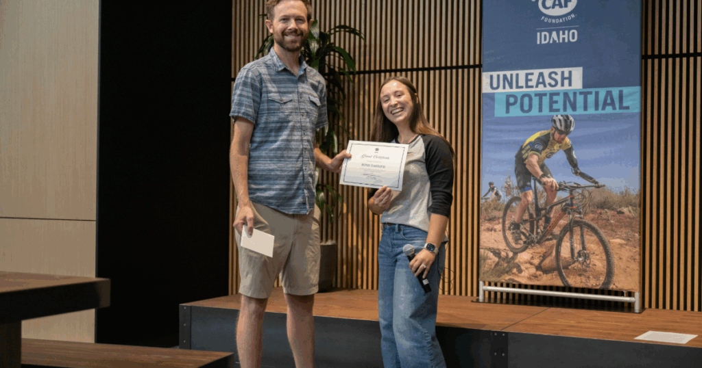 Athlete receiving a CAF Idaho grant certificate on stage during Water Sports Weekend