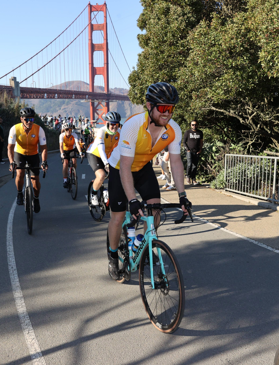 Cyclists ride together on a road near the Golden Gate Bridge during a group ride.