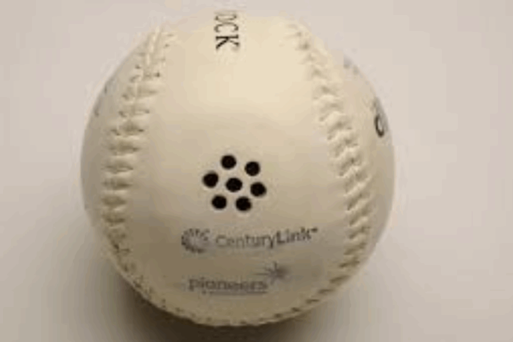 Close-up of a beeping baseball with small speaker holes that emit sound for players to track during the game.