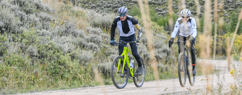 Willie Stewart rides a bright yellow bike on a gravel trail through a canyon path.