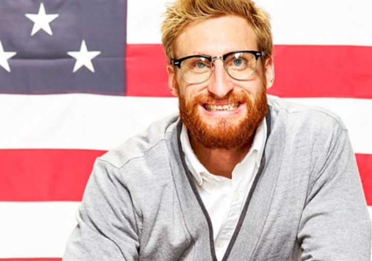 Brad Snyder smiling in front of the American flag