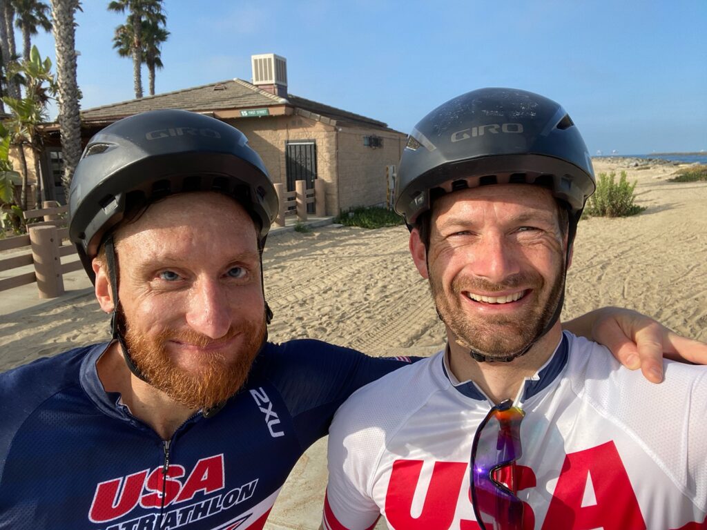 Brad Snyder and guide Greg Billington smiling in cycling helmets after training
