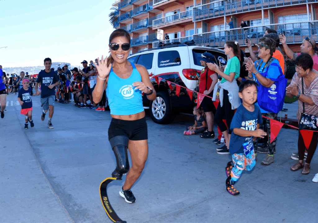 Scout Bassett waving while running with kids during the San Diego Triathlon Challenge Kids Run