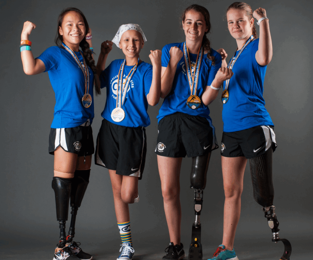 Group of young athletes wearing medals pose proudly together, showing strength and determination