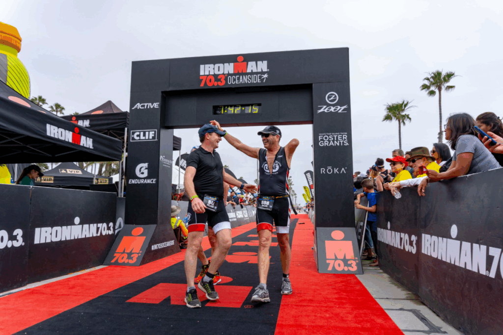 Miles O’Brien celebrates at the Ironman 70.3 Oceanside finish line with teammates after completing the race.