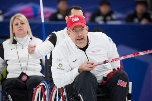 Steve Emt in a white Team USA jacket shouting instructions during a match.