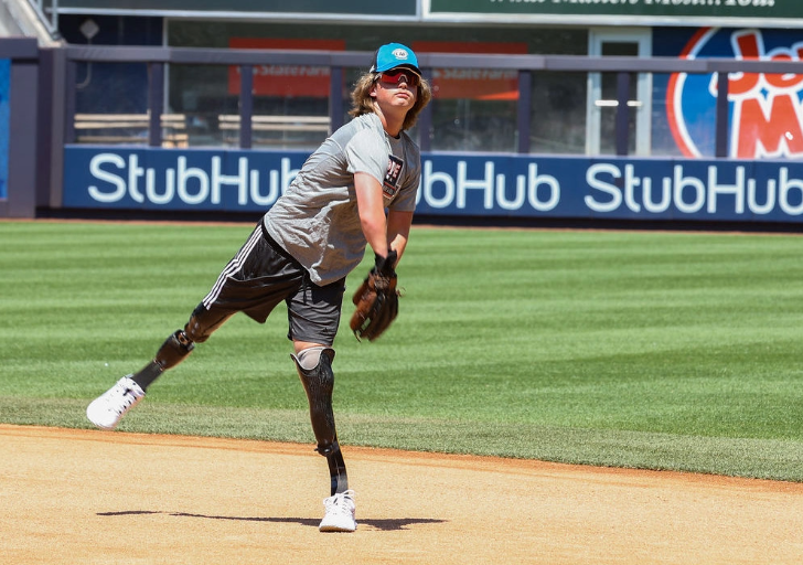 A teenage athlete throws a baseball on the infield during a practice session.