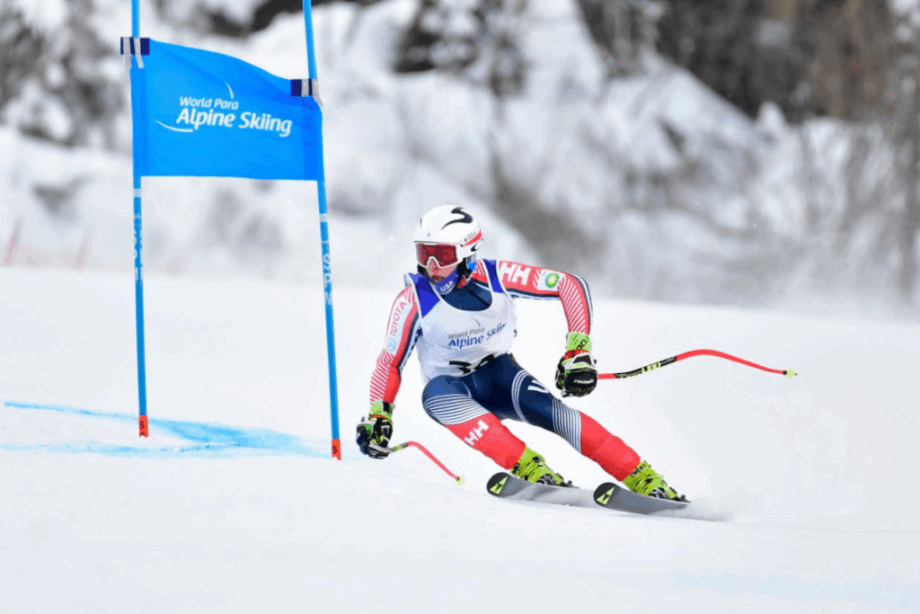 An alpine skier in action during a slalom race with a blue gate banner reading "World Para Alpine Skiing."