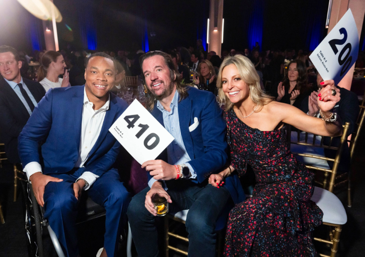 Guests at the Celebration of Heart gala hold up auction paddles during the live fundraising event.
