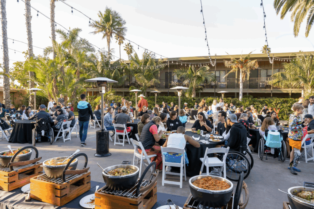 Athletes, families, and volunteers gathered at outdoor tables for a community dinner during San Diego Triathlon Challenge weekend.