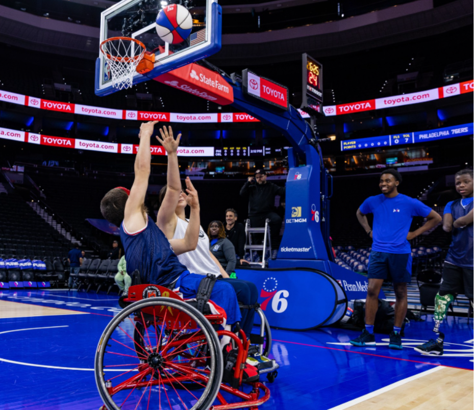 Wheelchair basketball player blocking another from taking a shot