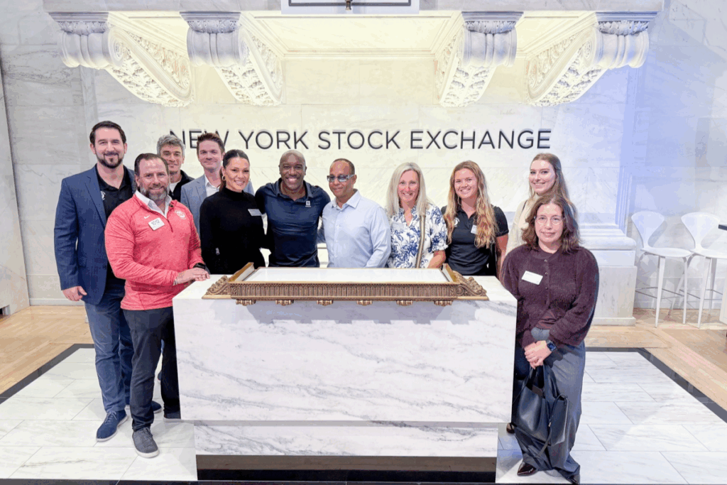 CAF team members stand together inside the New York Stock Exchange following the bell-ringing event.