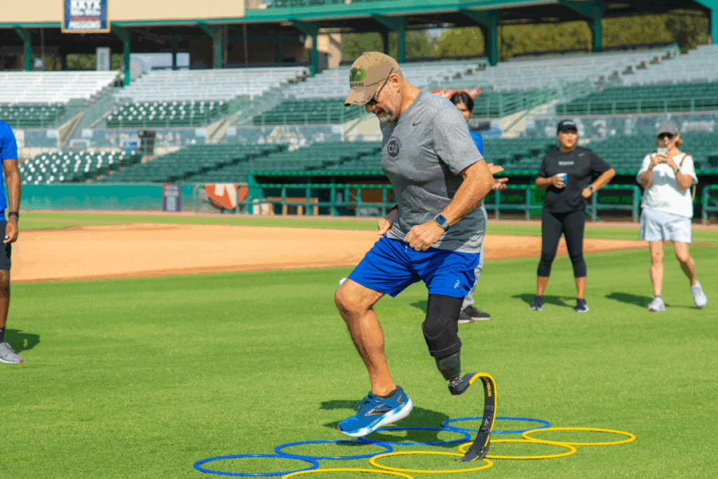 Athlete with a running blade practices agility drills on the field during a CAF and Össur Mobility Clinic.