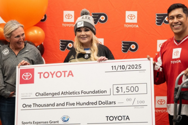 CAF and Toyota representatives present a Sports Expenses Grant check to the Challenged Athletes Foundation during a sled hockey event.