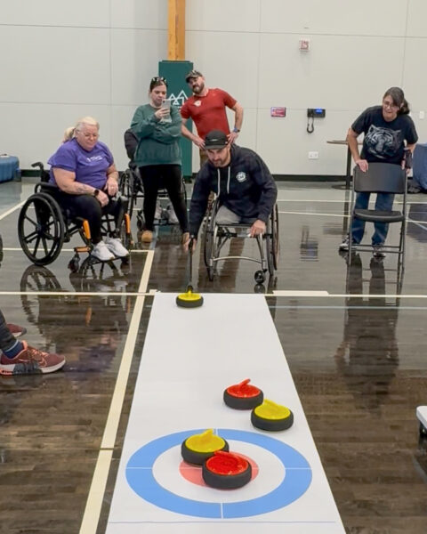 People playing indoor curling with a focus on accessibility.