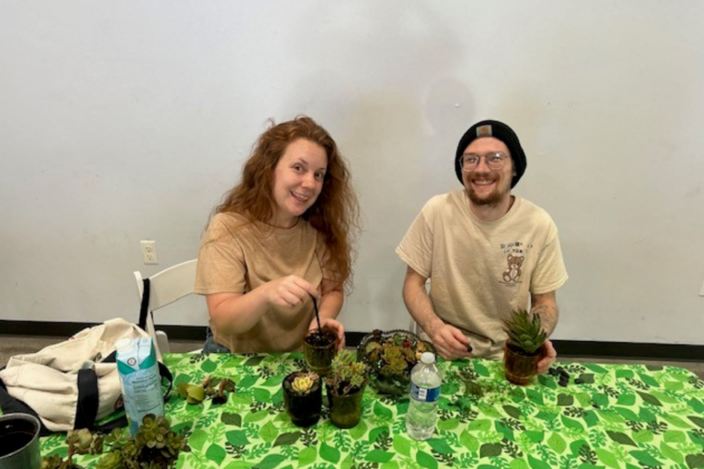 Two participants plant succulents at a hands-on workshop fundraiser supporting adaptive sports programs.