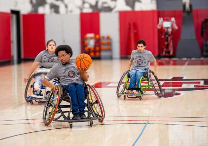 Athletes at a wheelchair basketball clinic on the court at SDSU