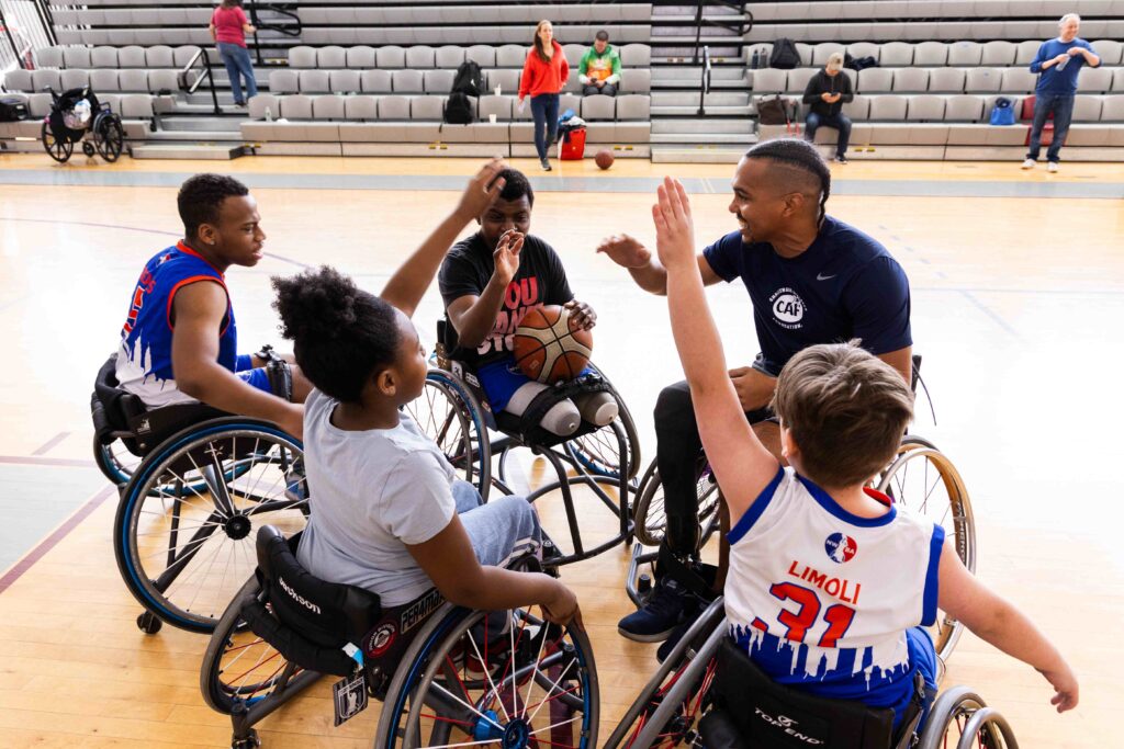 CAF Northeast Multi Sport Clinic at Riverdale, showing atheletes in wheelchairs playing wheelchair basketball on the court