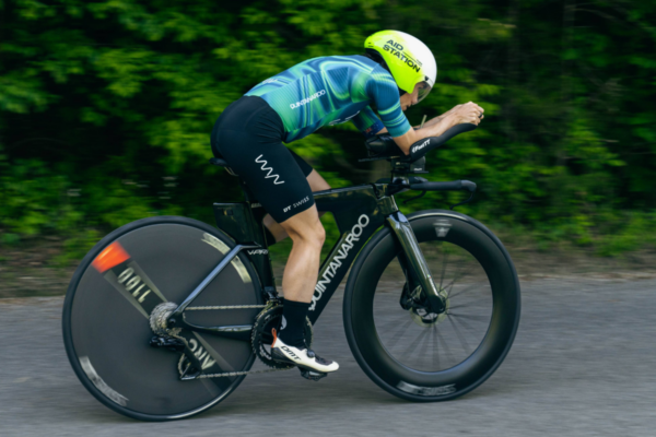 Cyclist riding a Quintana Roo time trial bike in an aerodynamic position during a cycling training session.