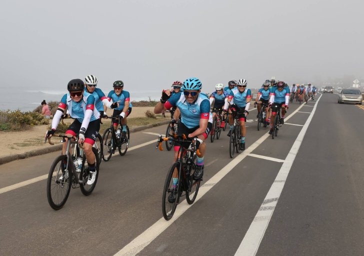 Cyclists ride along a coastal roadway during a Challenged Athletes Foundation community cycling event near the ocean.