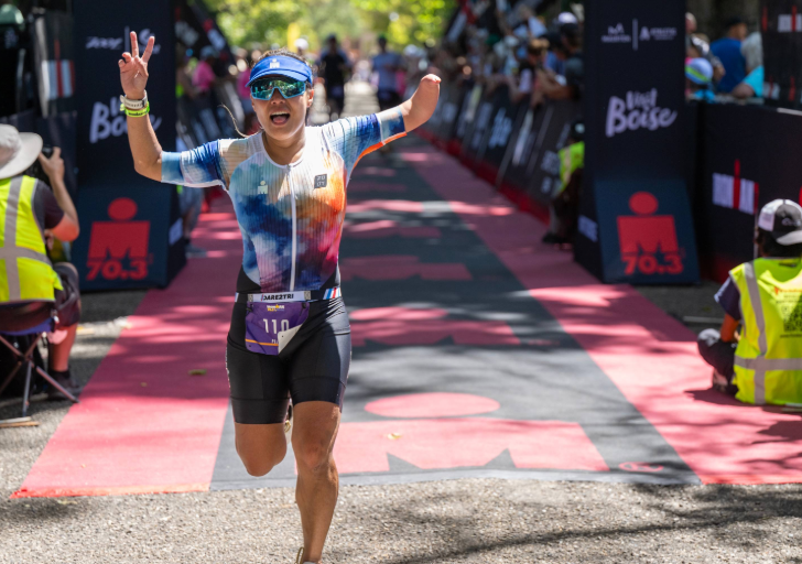 CAF athlete crosses the finish line at IRONMAN 70.3 Boise with raised arms during an adaptive triathlon event.