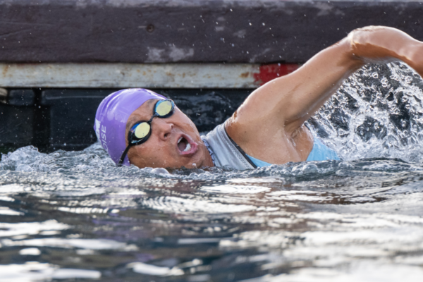 Adaptive athlete swims during the IRONMAN 70.3 Boise race, creating splashes while competing in the swim segment.