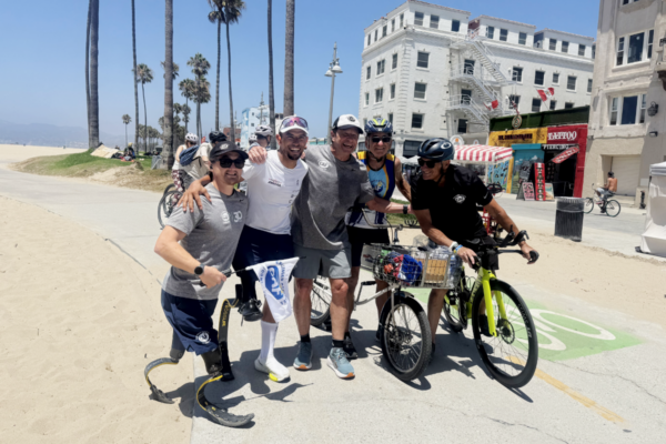 Mohamed Lahna stands with cyclists and Challenged Athletes Foundation supporters along the Venice Beach boardwalk during Triathlon Across America.
