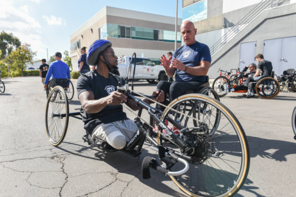 Adaptive athlete using a handcycle while receiving instruction during a Challenged Athletes Foundation cycling clinic.